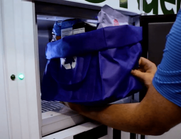 a customer retrieves their order from a refrigerated smart locker