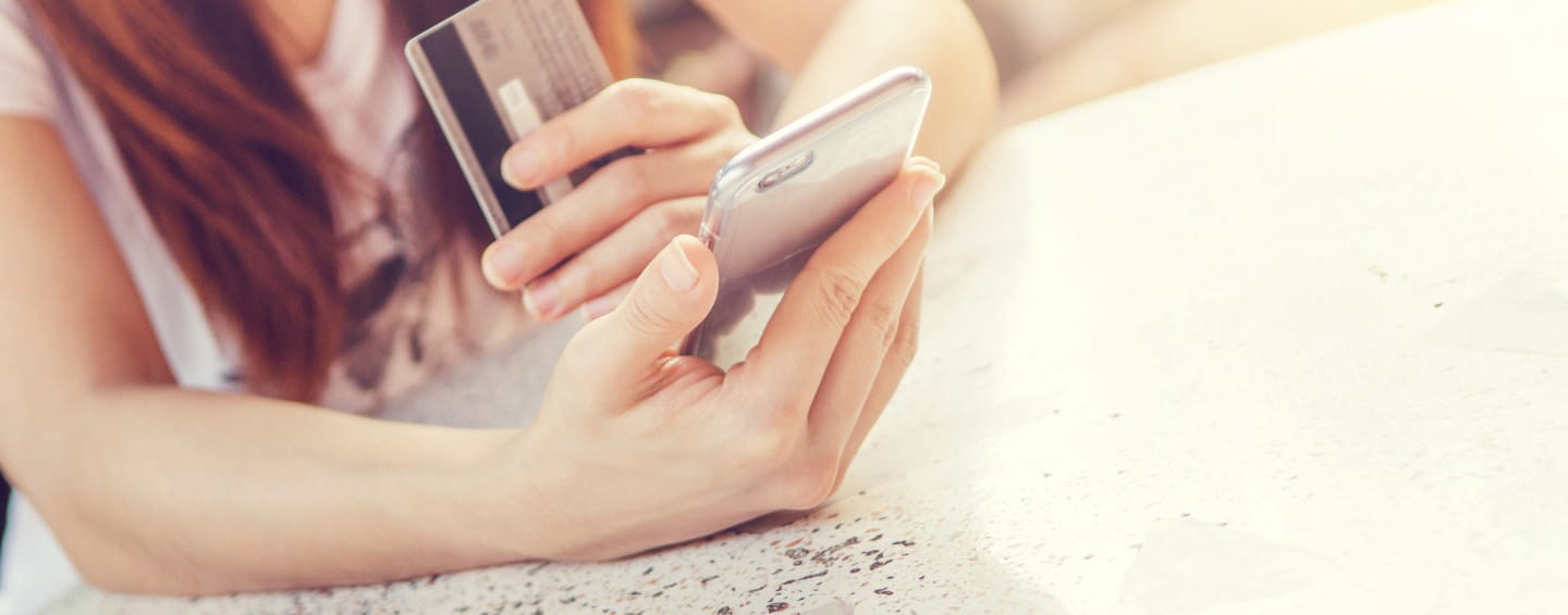 A woman makes a purchase via mobile phone